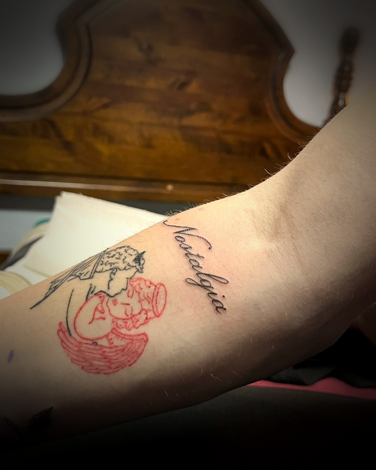 Lettering fine line y figura en línea roja en el antebrazo